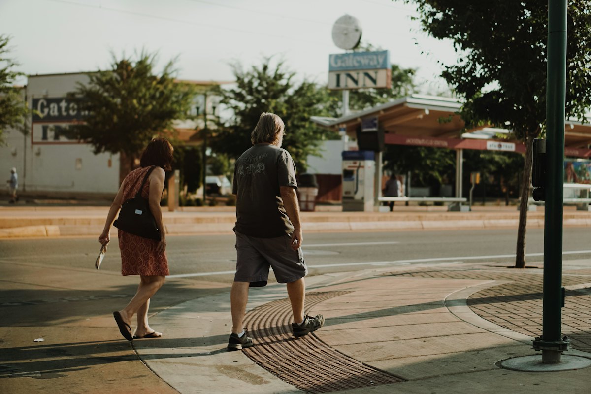 Two people walking together on a city street at dusk