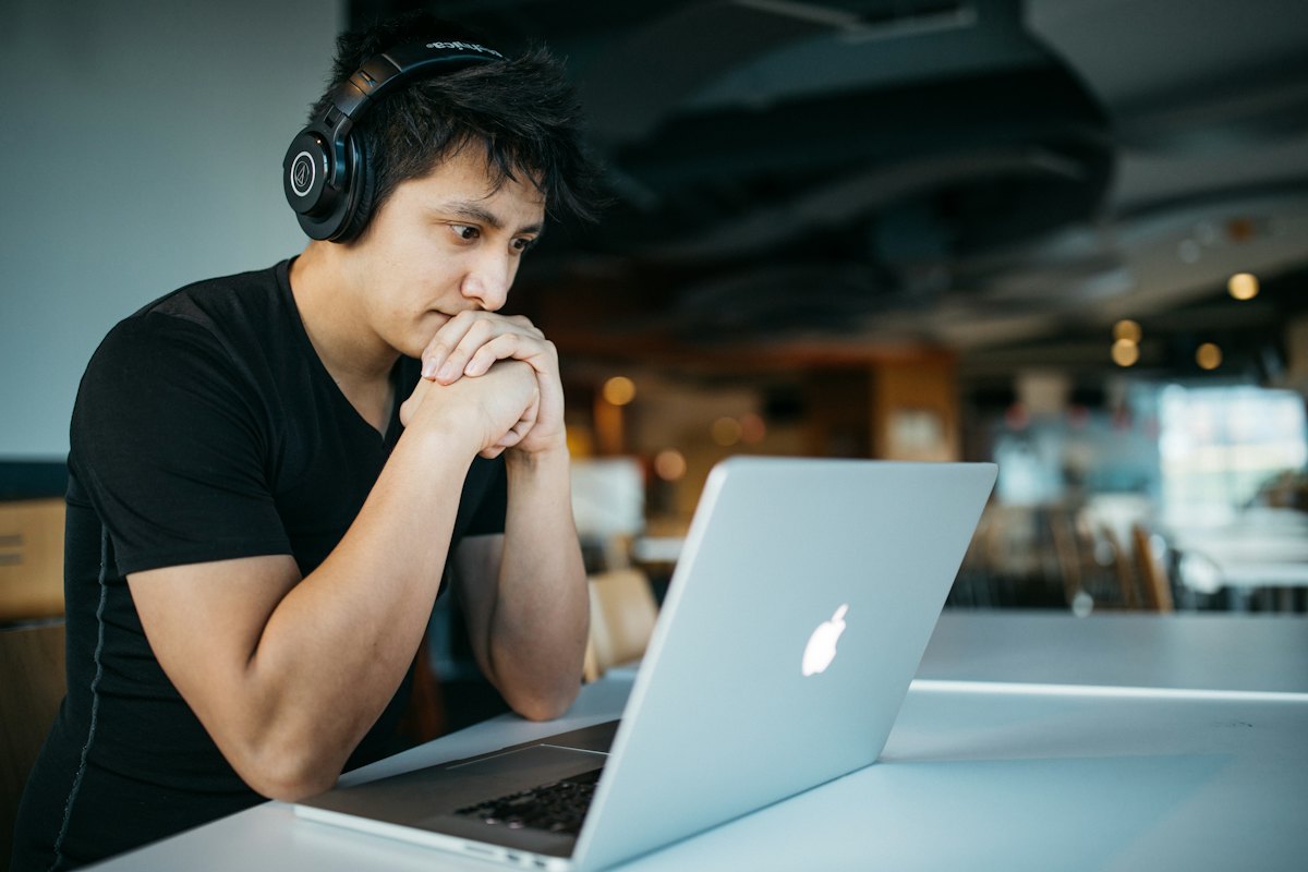 A student with headphones focused on a laptop